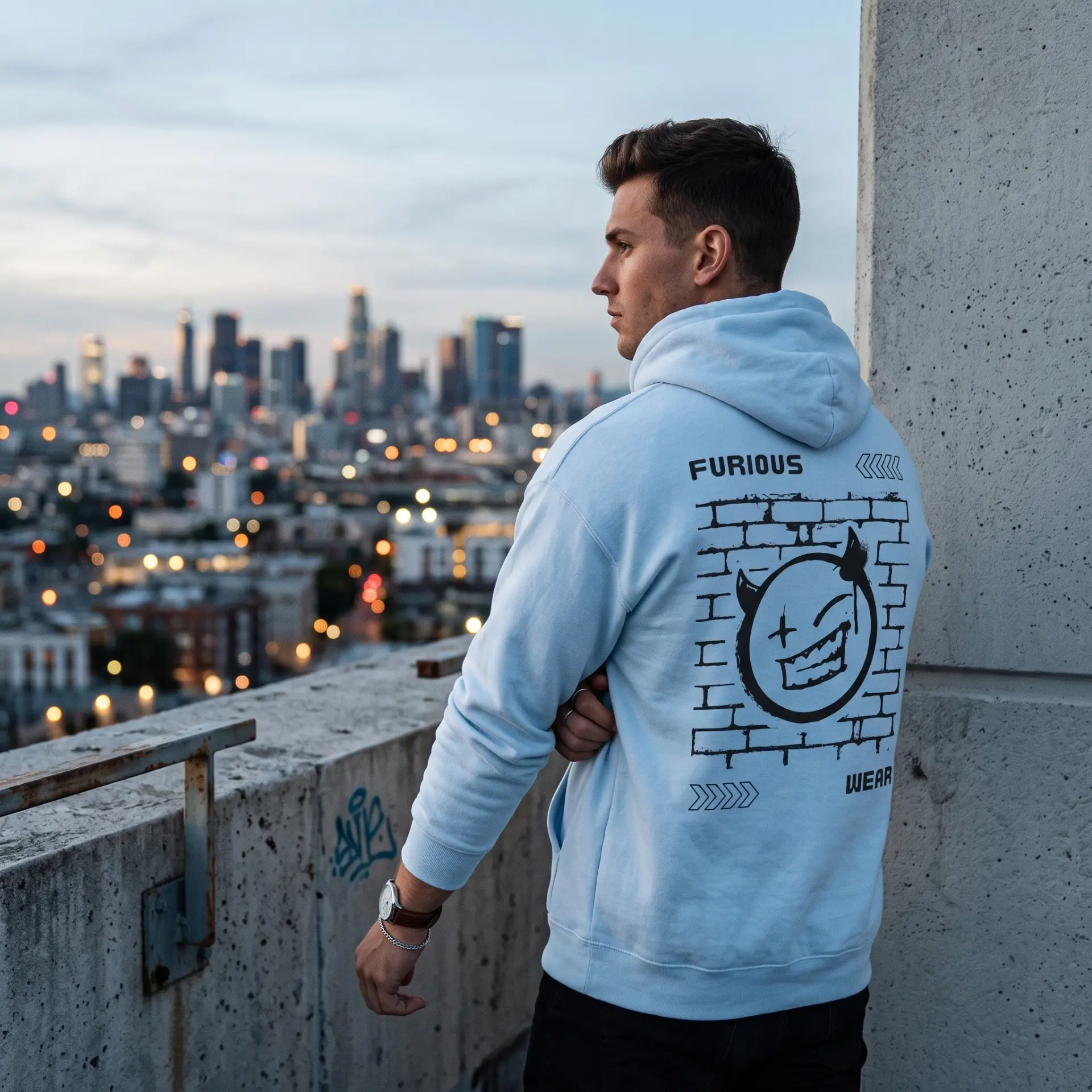 Model at dusk wearing the light blue Furious Wear graffiti back-print hoodie